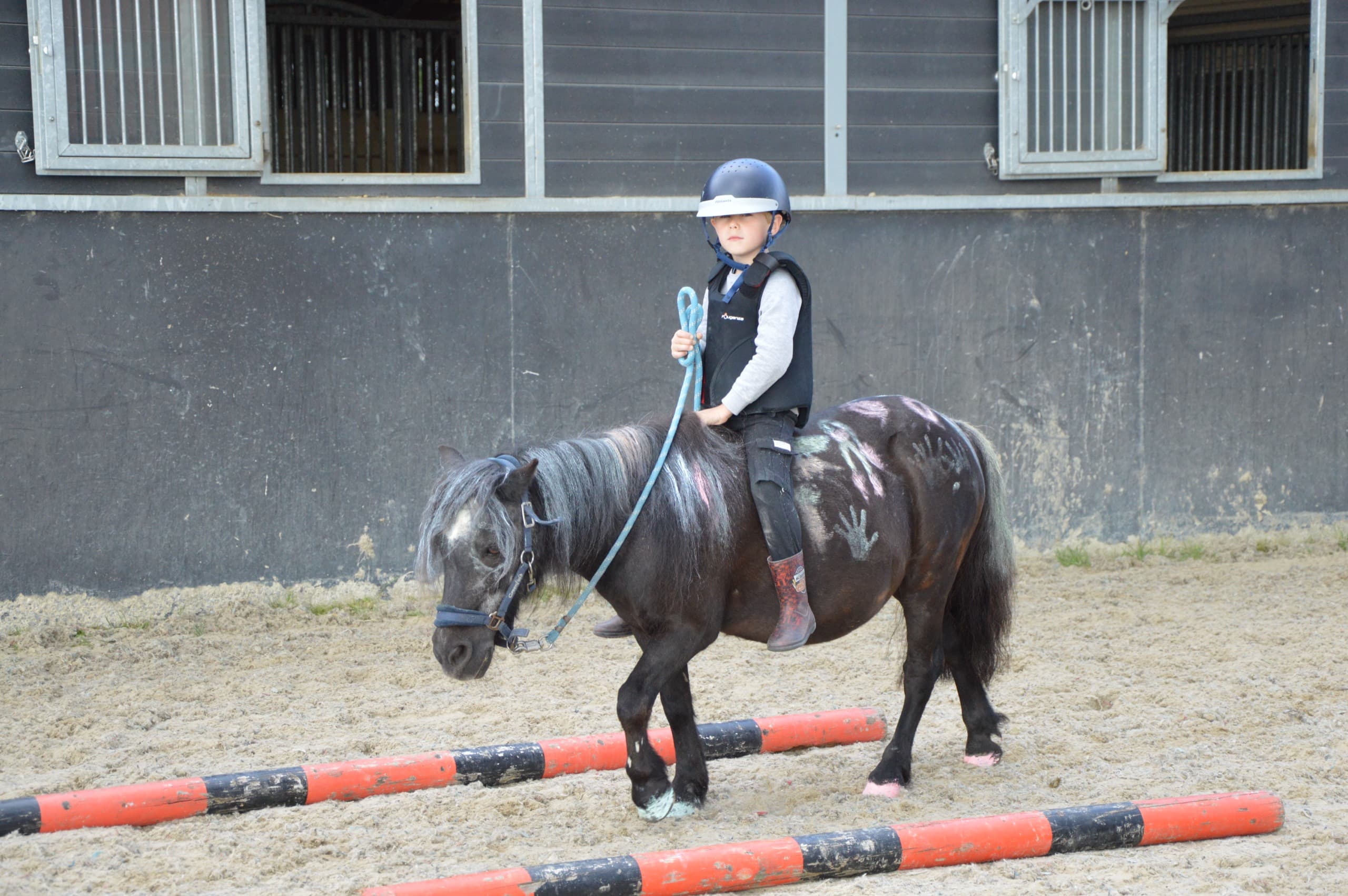 Jong kind maakt voor het eerst kennis met een pony bij Start 2 Pony