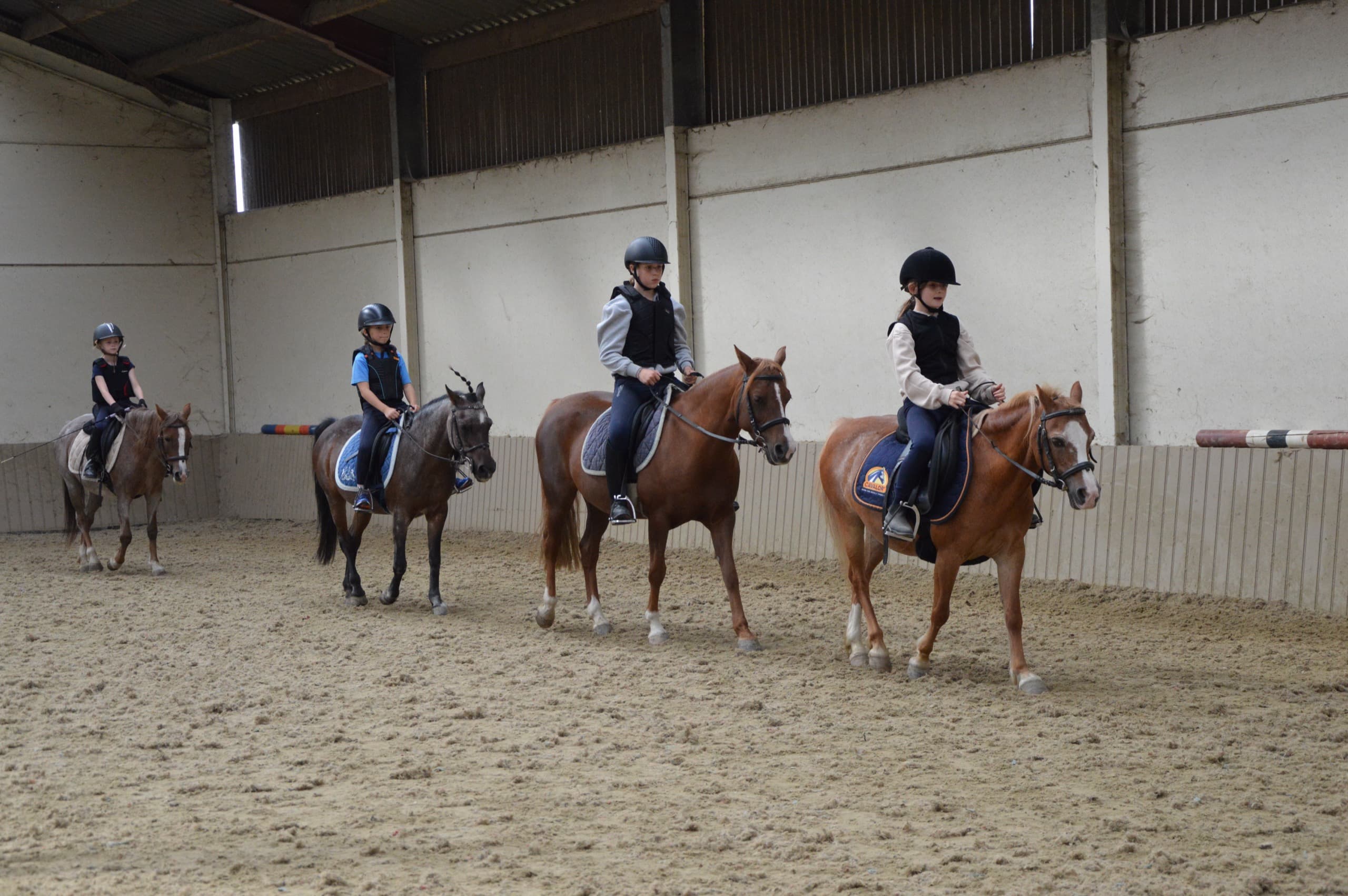 Kind rijdt op een pony tijdens een wekelijkse rijles